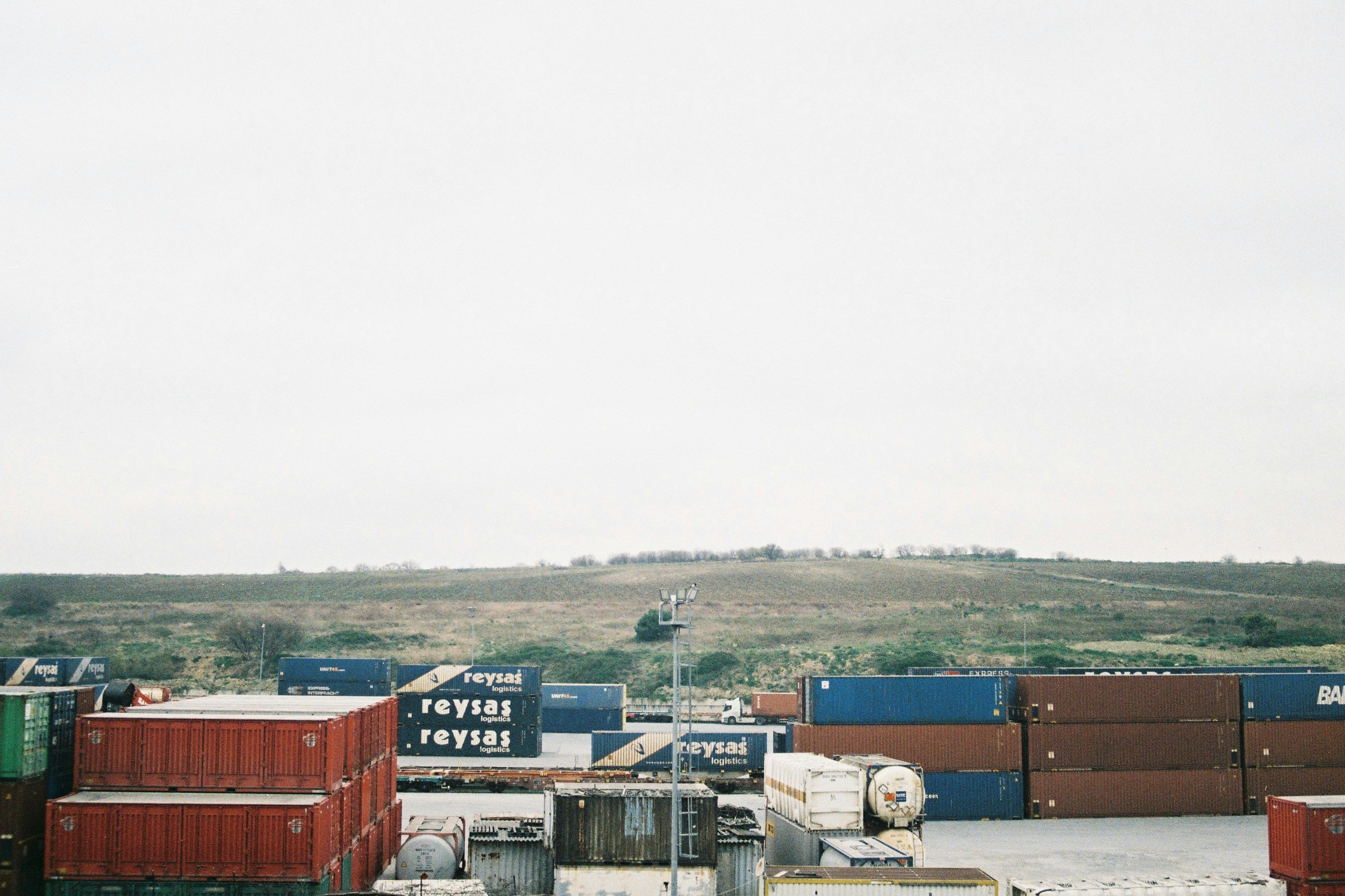 Stacked shipping containers symbolizing layered Section 301 and IEEPA tariffs