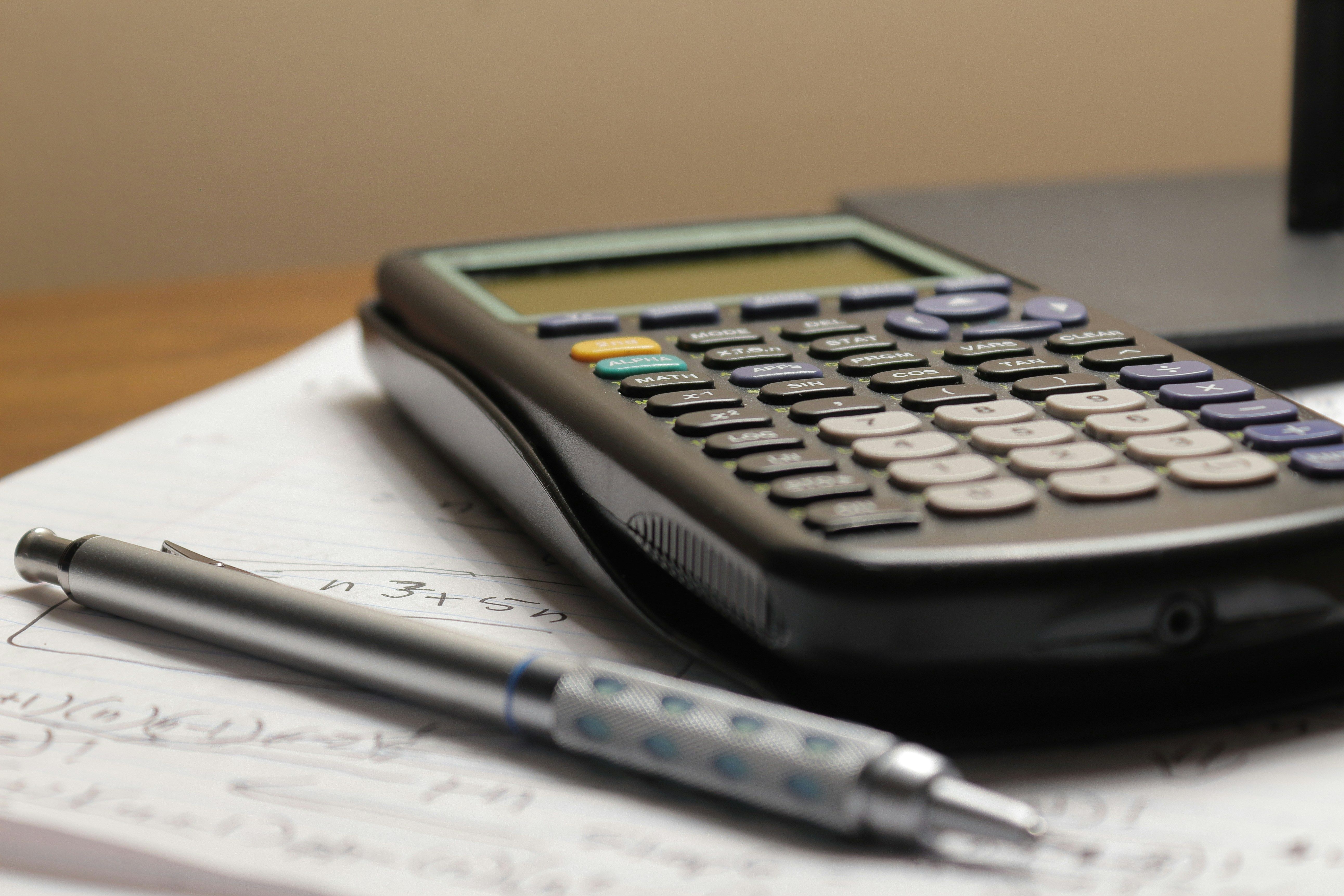 Accounting ledger and calculator representing reconciliation entries
