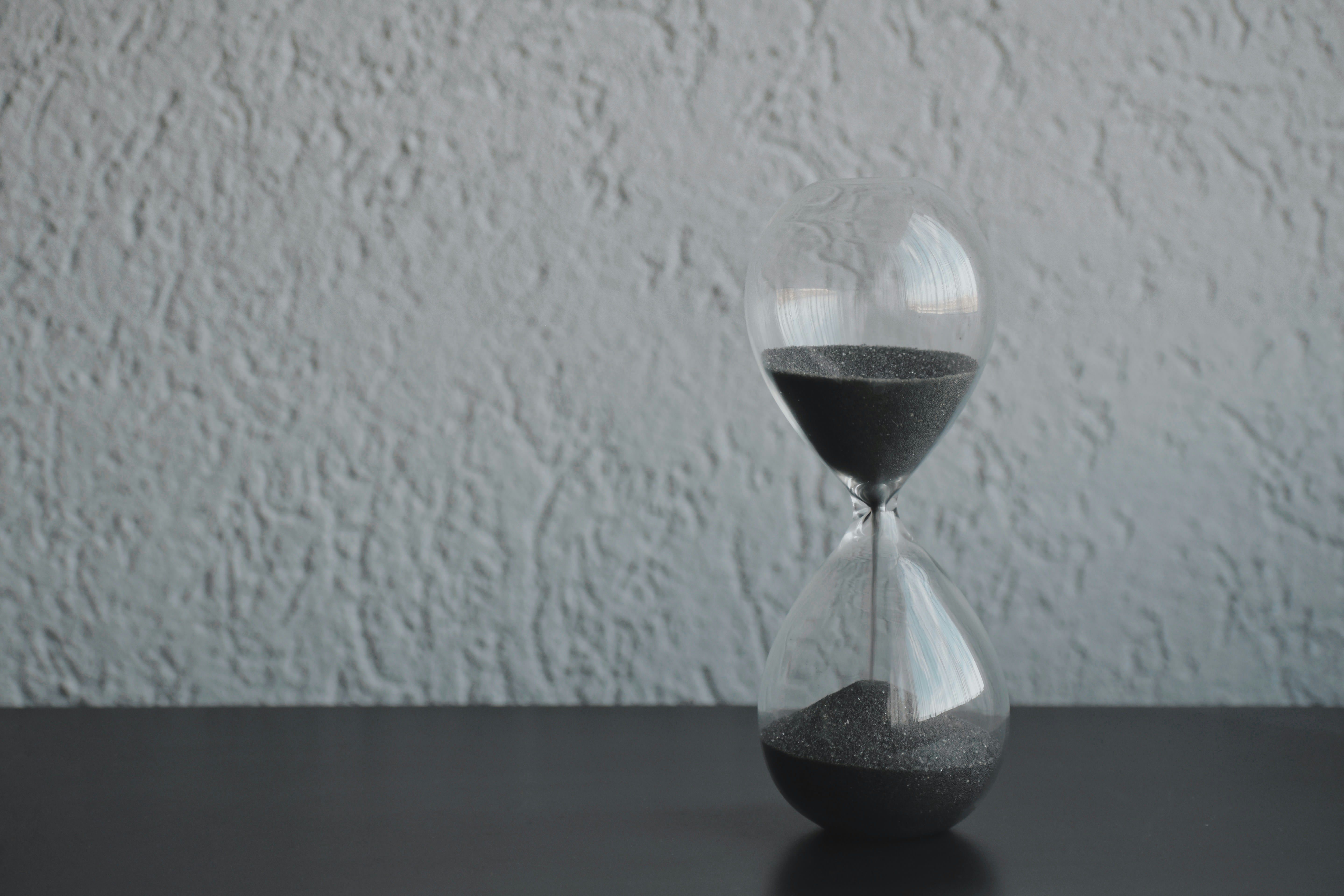 Hourglass with sand falling, illustrating extended refund timing